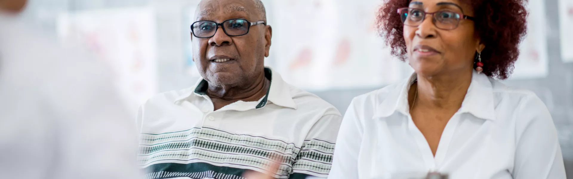 Imagem de um casal de idosos falando com um medico