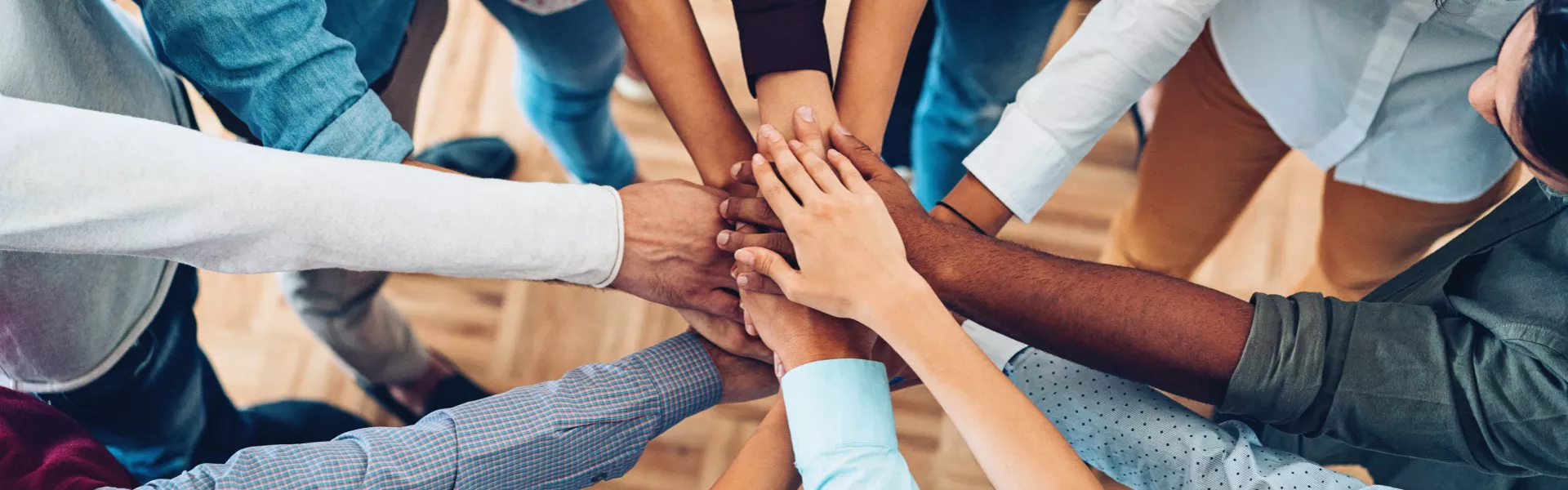 Imagem de um grupo de pessoas dando as mãos em um circulo