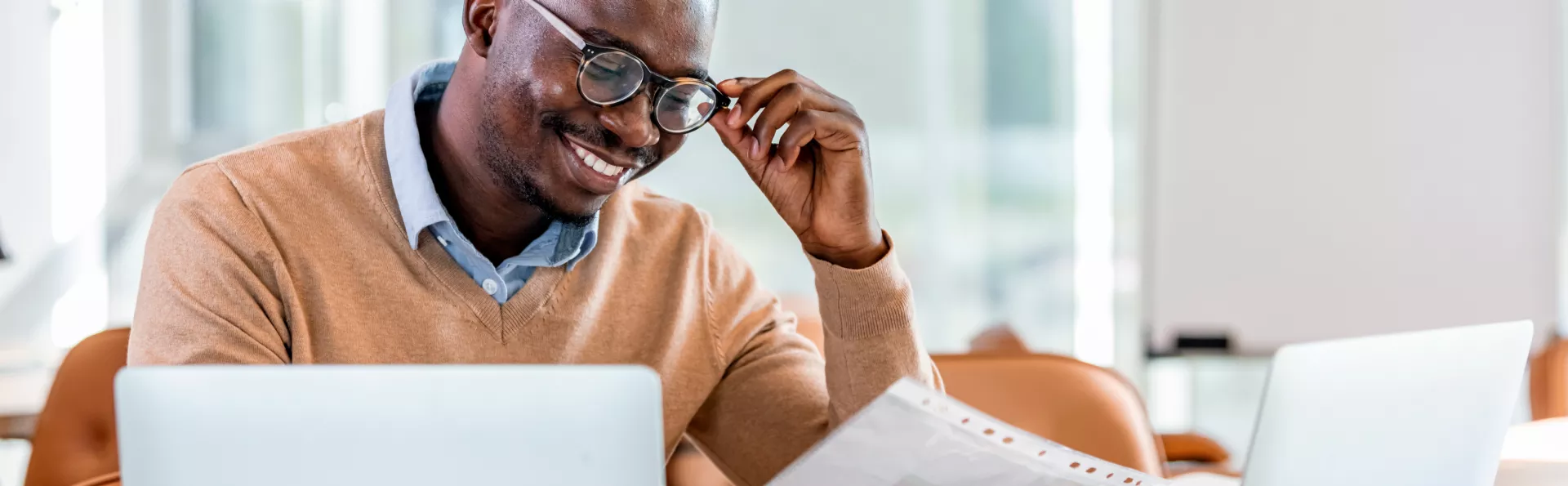 Homem com oculos usando seu laptop