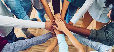 Mãos de diversas pessoas reunindo-se
