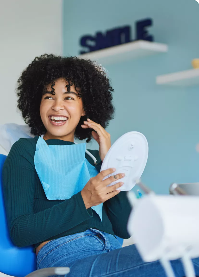 Imagem Mulher sorrindo com um espelho na mão